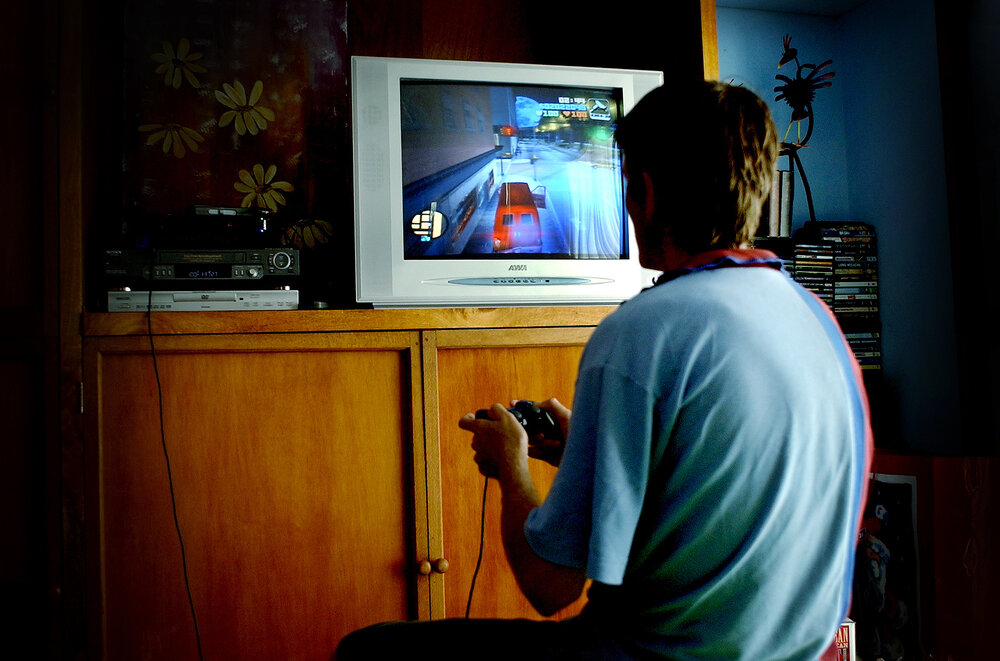 Man playing video games on TV, Ipswich, January 2005