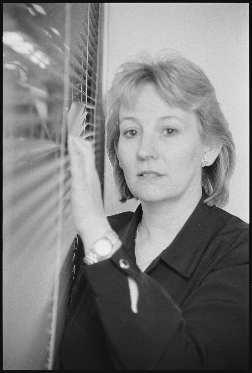 Unidentified woman looking through venetian blinds, location unknown, 5th August 1994