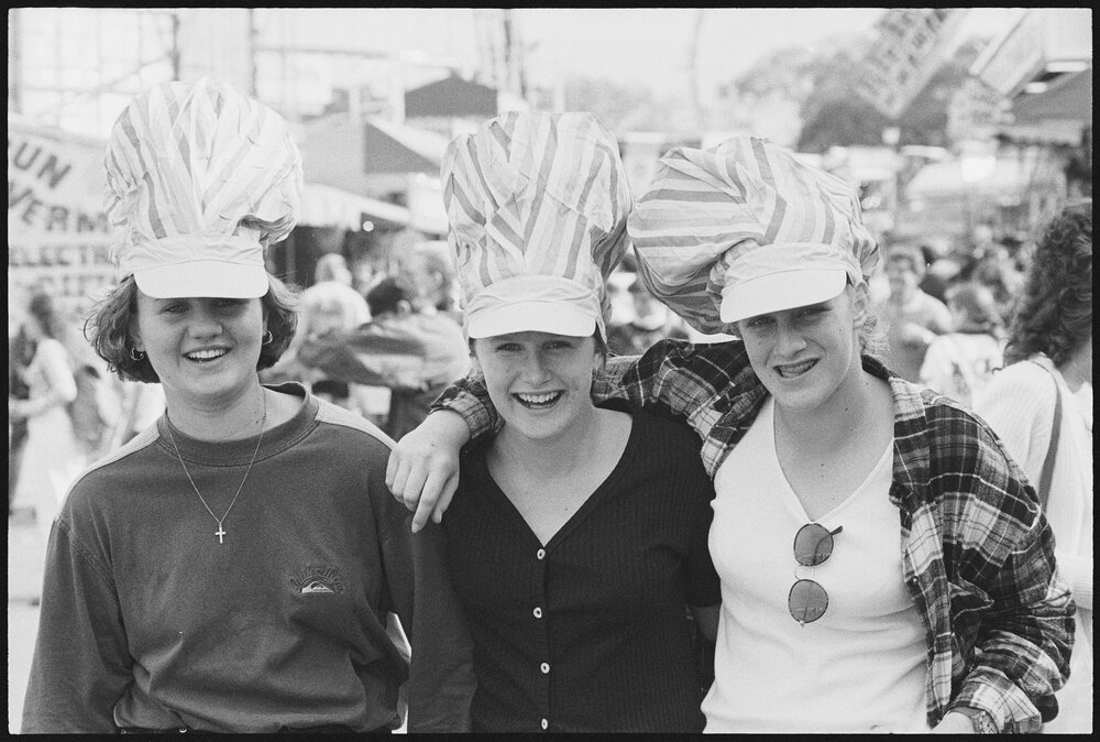 Three unidentified young women wearing novelty hats at the Ekka, Brisbane Showgrounds, Brisbane, 21st August 1994