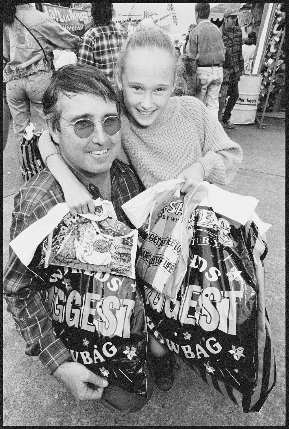 Unidentified man and girl with showbags at the Ekka, Brisbane Showgrounds, Brisbane, 21st August 1994