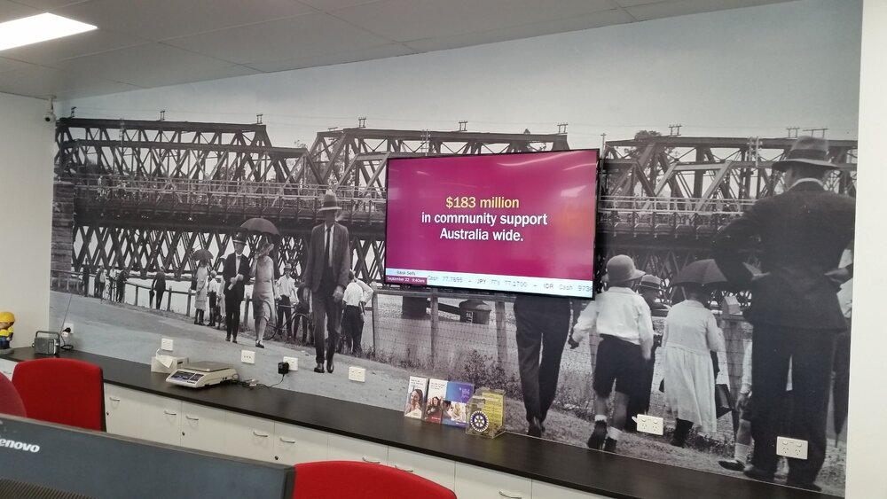 Whitehead Studio image of flood waters under the Bremer River Rail Bridge (1930s), used as a feature wall at the Bendigo Bank Booval branch, Ipswich, 2018