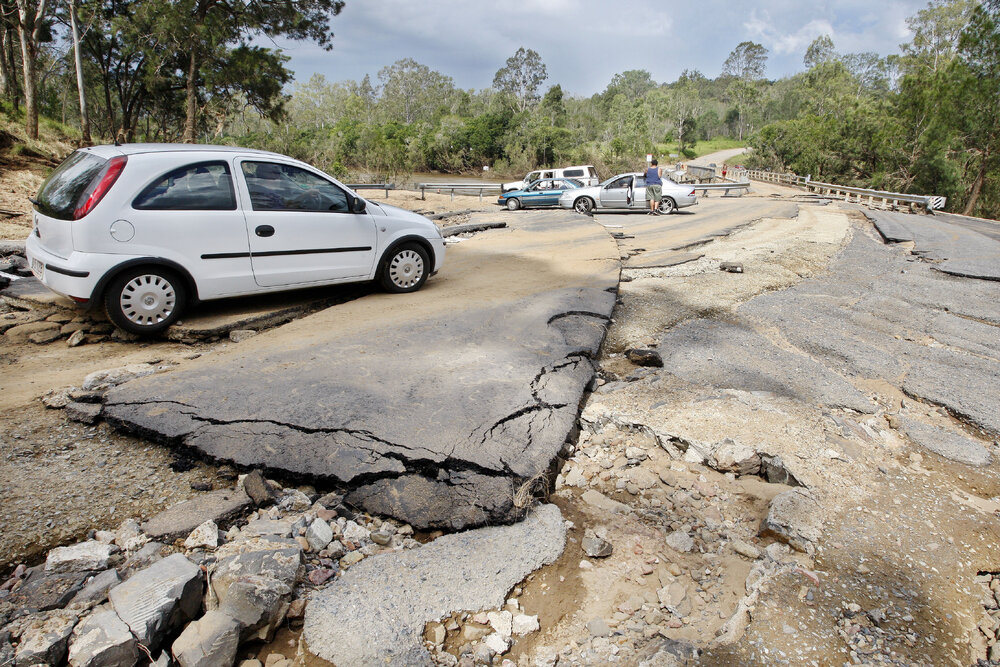 Members of the public riding through the road damage at the Kholo bridge which is currently closed after flood damage, Ipswich, 3rd January 2011