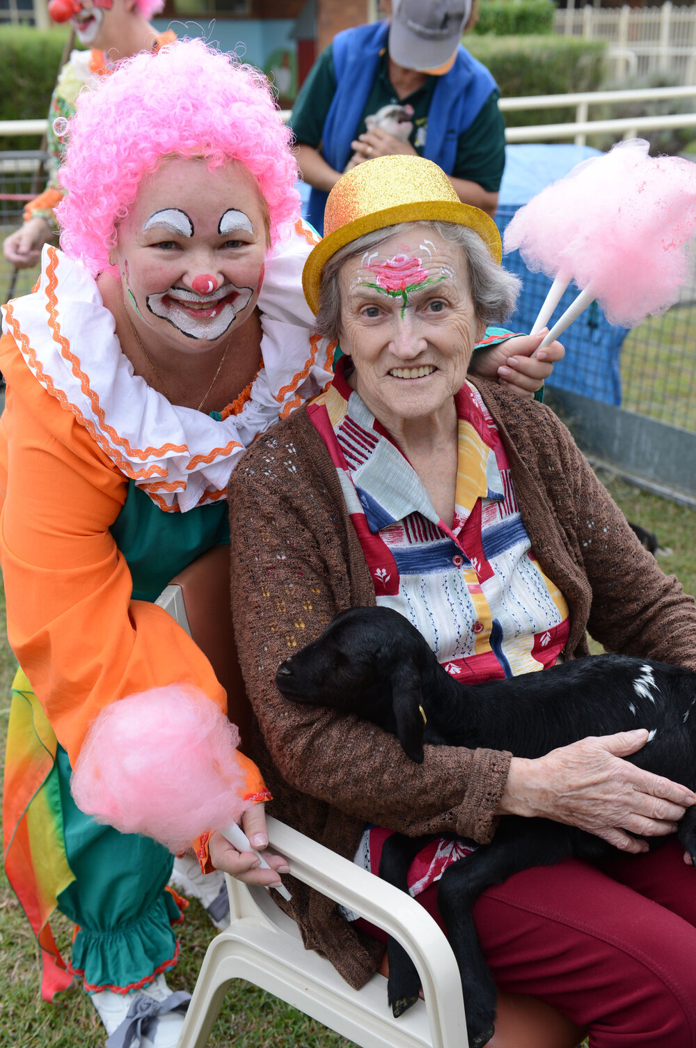 Leigh Wilkins dressed as a clown, with resident Maureen Cassidy and a lamb from the animal nursery that was part of the show-themed day at St Mary's Hostel, Ipswich, 16 May 2013