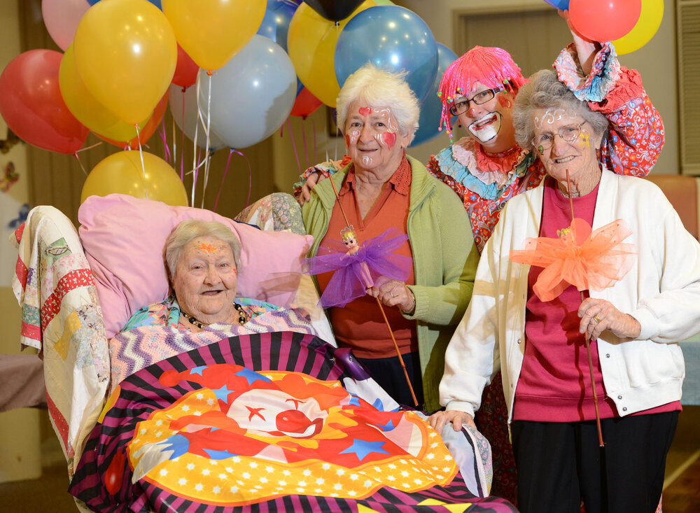 Residents Chelmer 'Chum' Voight, Dorothy Harris and Barbara Kopelke with employee Michelle Hammill, dressed as a clown, at the show-themed day at St Mary's Hostel, Ipswich, 16 May 2013