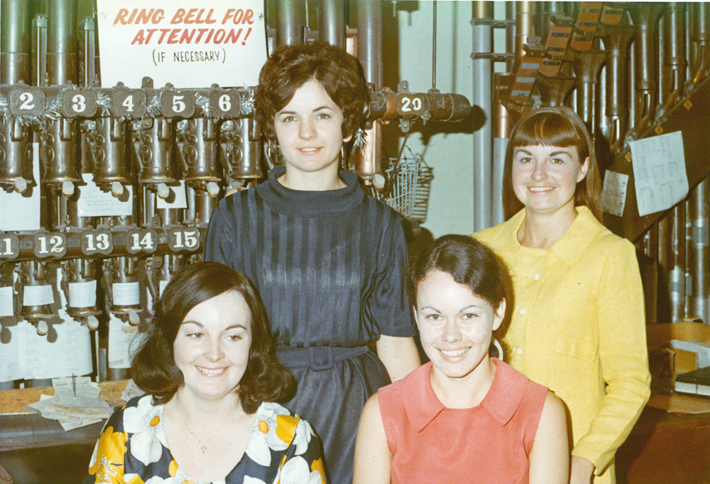 Staff at T. C. Beirne's, with pneumatic cash carrier in background, Ipswich, 1971