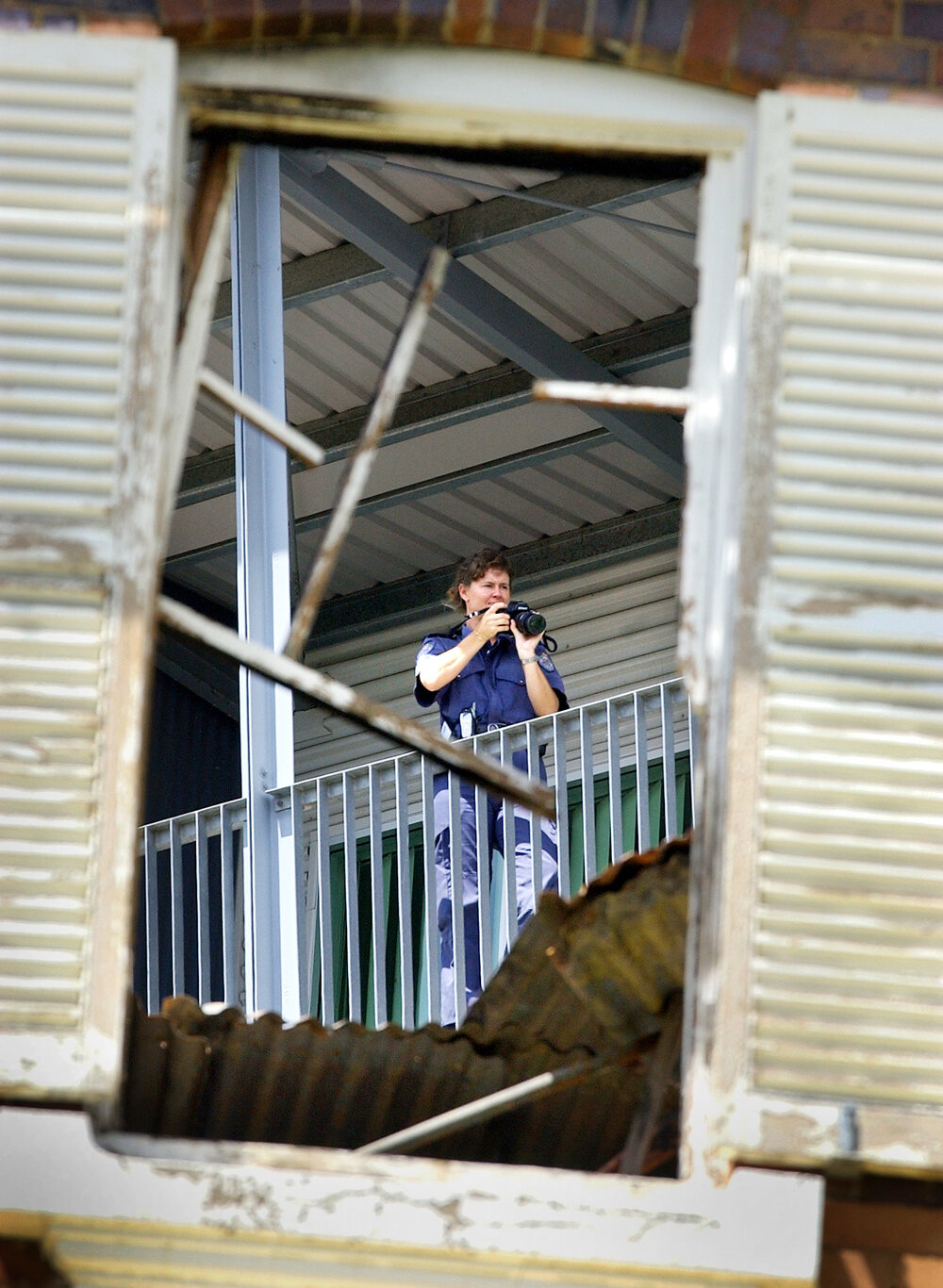 A police scenes of crime officer photographs the fire ravaged remains of the Ipswich Hospital's Old Education Centre, Ipswich, 7 February 2005 