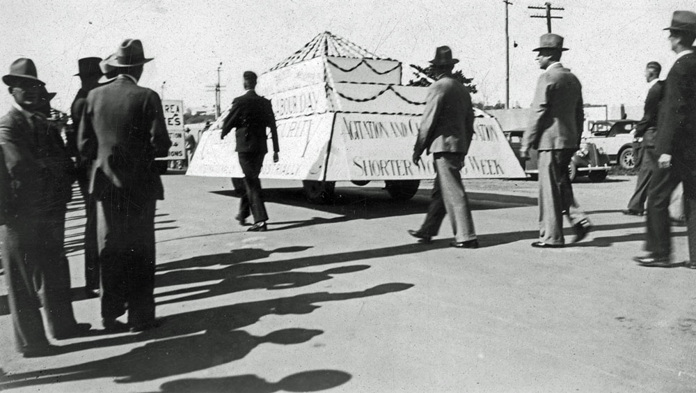Men marching with float 'Agitation and Closer Organisation for a shorter working week.'  Ipswich, 1940