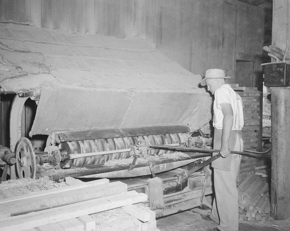 Worker using sawmill machinery at Kruger Sawmill, Byrne Street, Bundamba, Ipswich, 1959