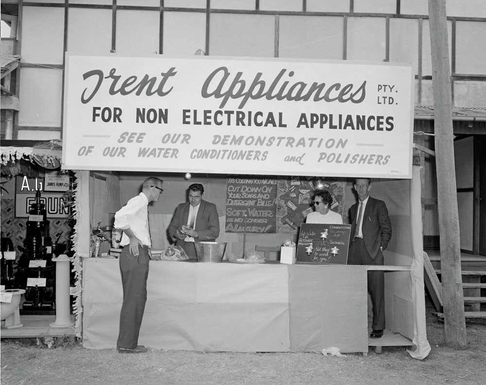 Three men and a woman at Trent Appliances Pty Ltd display, Ipswich Show, Ipswich, 1960