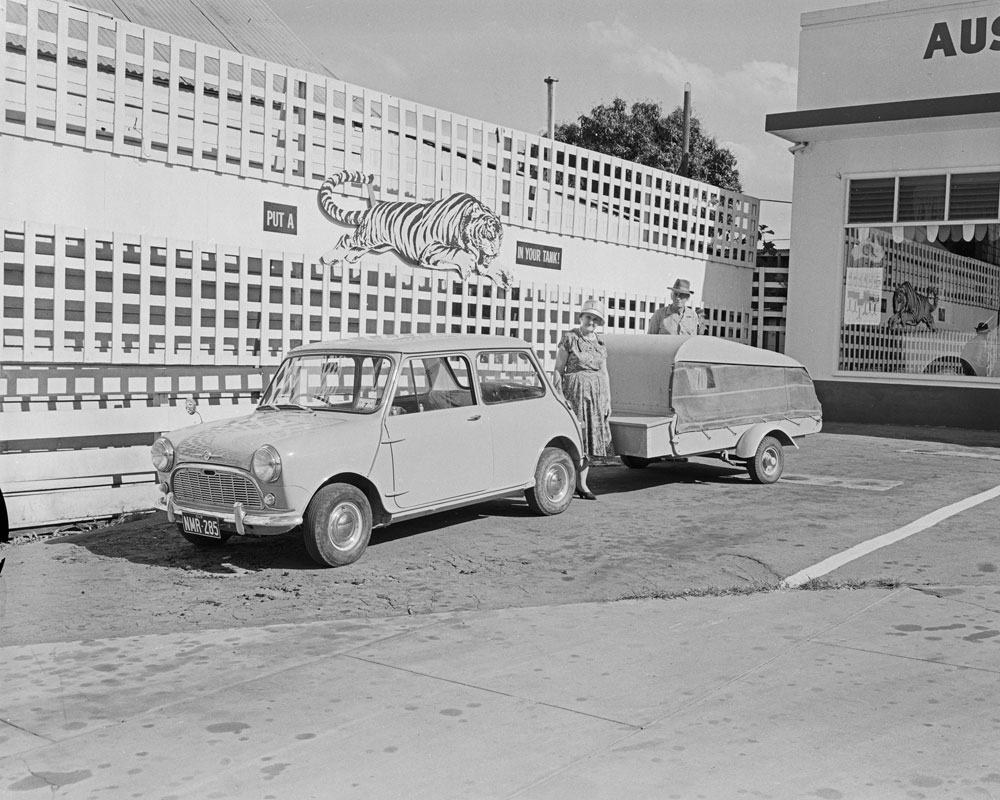 Couple at Alpha Motors with their Mini Minor and Caravan, Brisbane Street, Ipswich, 1963