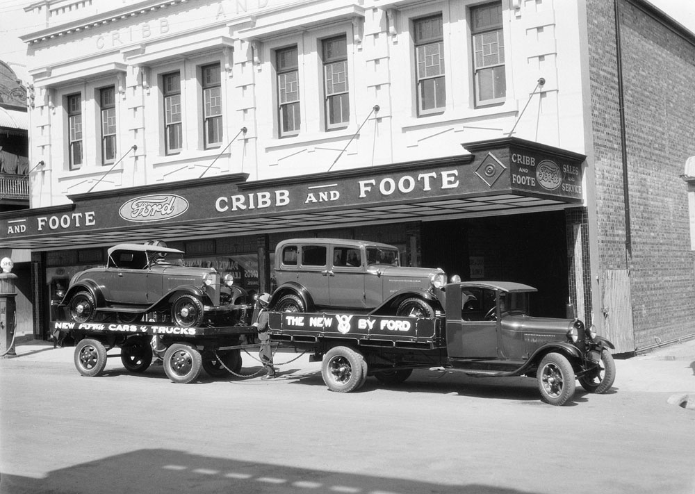 Ford V8 car, on truck, in front of Cribb &amp; Foote Motor Garage,  144 Brisbane Street, Ipswich, c.1936
