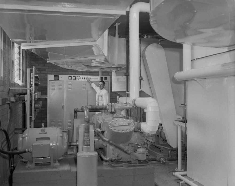 Ipswich Bowling Alley staff member with air-conditioning unit, corner Brisbane and Limestone Streets, Ipswich, 1963