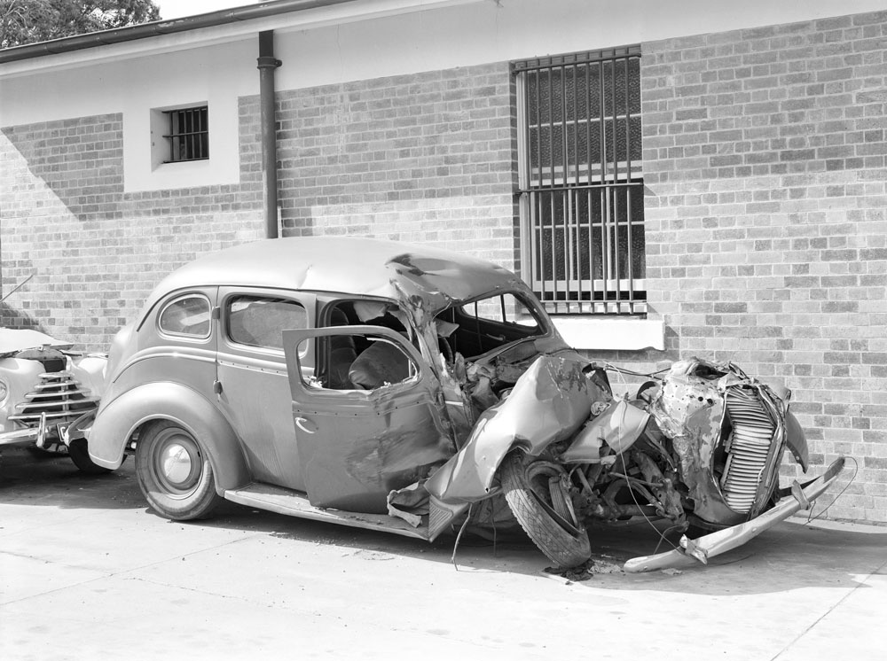 Damaged car at SGIO building, Brisbane Street, Ipswich, 1954