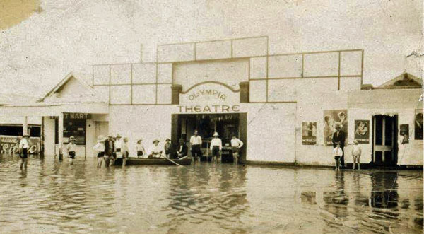 Children at the front of the Olympia Theatre, Brisbane Street, during floods, Ipswich, 1931