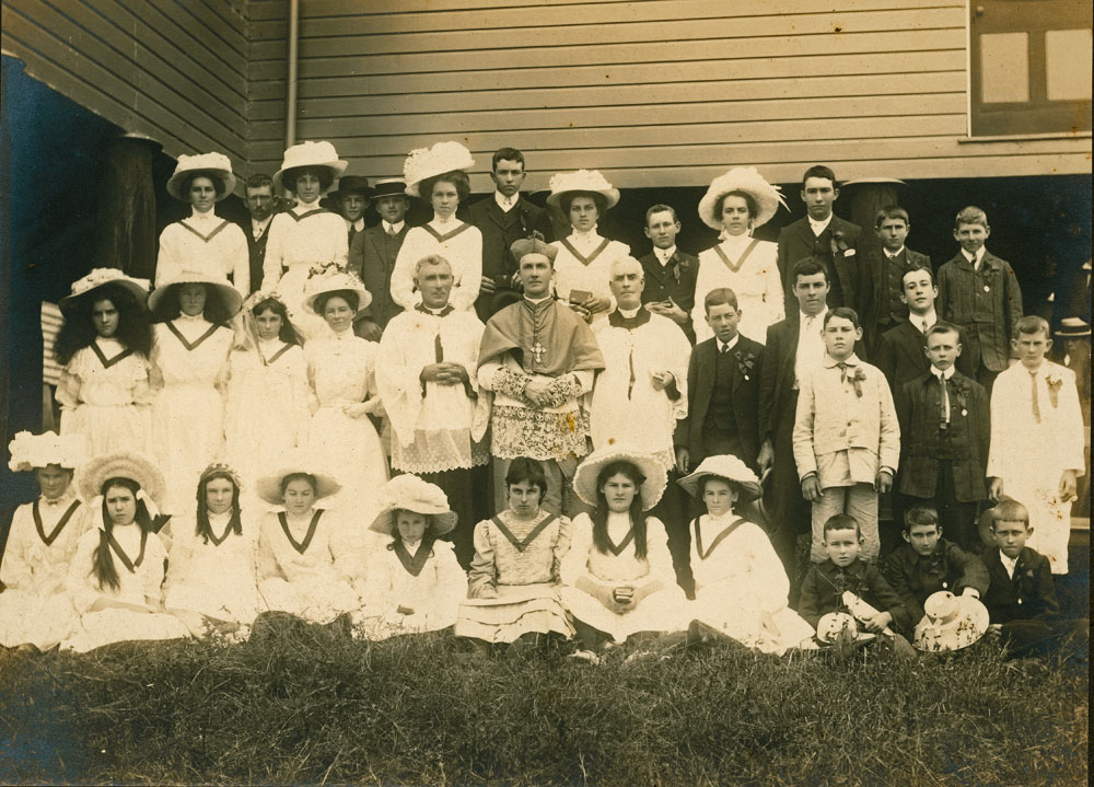 Father Horan with an unidentified group of people in front of unidentified Church in the St Mary's Catholic Church Parish, c.1900
