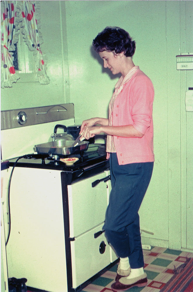 Woman cooking in kitchen of home at 7 Alice Street, Blackstone, Ipswich, 1963