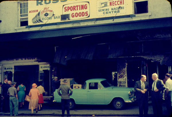 Shoppers and onlookers in at the  aftermath of fire at Russ Dore Mercury Centre Showroom, Brisbane Street, Ipswich, 1963