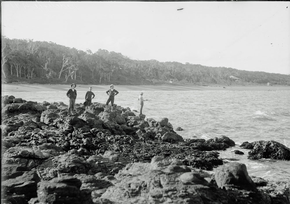 Unidentified group of boys fishing on rocks at Woody Point, Redcliffe, 1900s