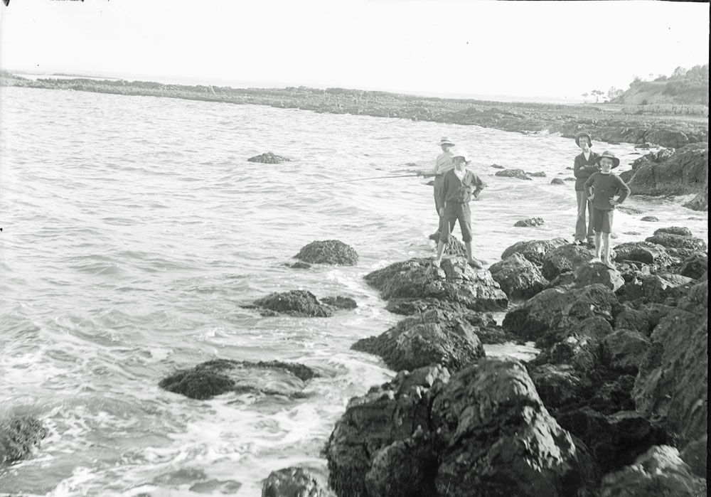 Unidentified group of boys fishing on rocks at Woody Point, Redcliffe, c.1900's