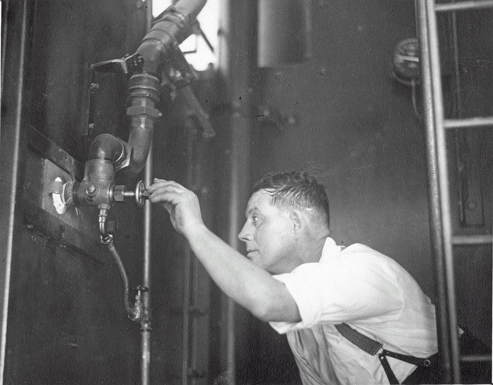 Interior of Incinerator with unidentified man priming furnace with oil injector, Ipswich, November 1936