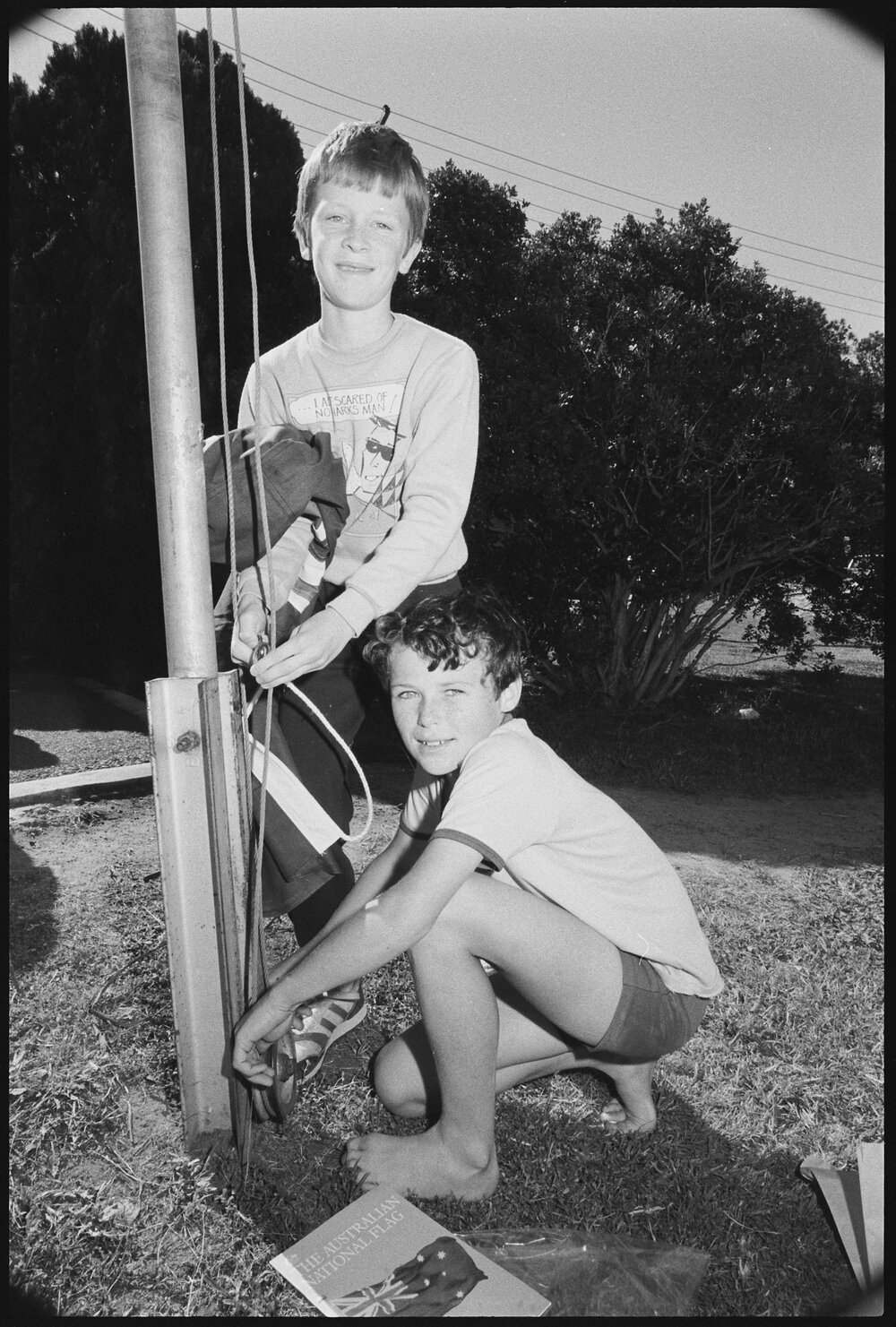 Two unidentified boys raising an Australian Flag on a flag pole, Ipswich, September 1987