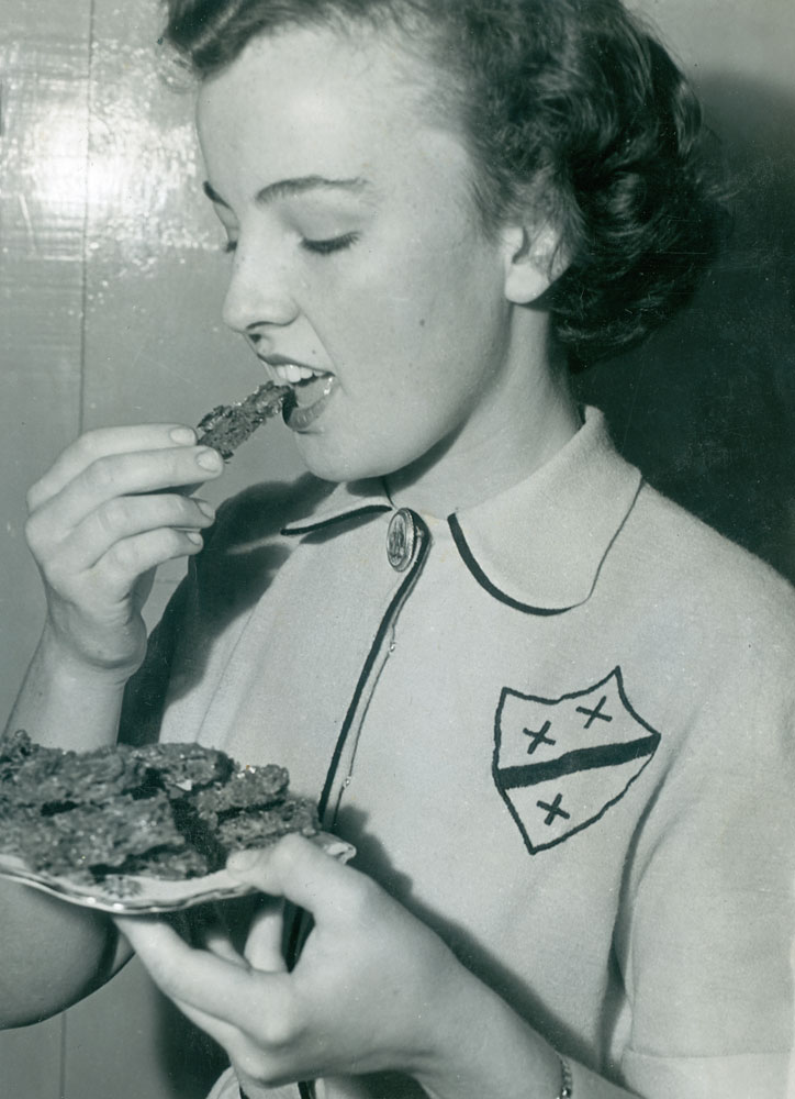Claire Evans, trying out her mother's cakes, Goodna, Ipswich, 1953