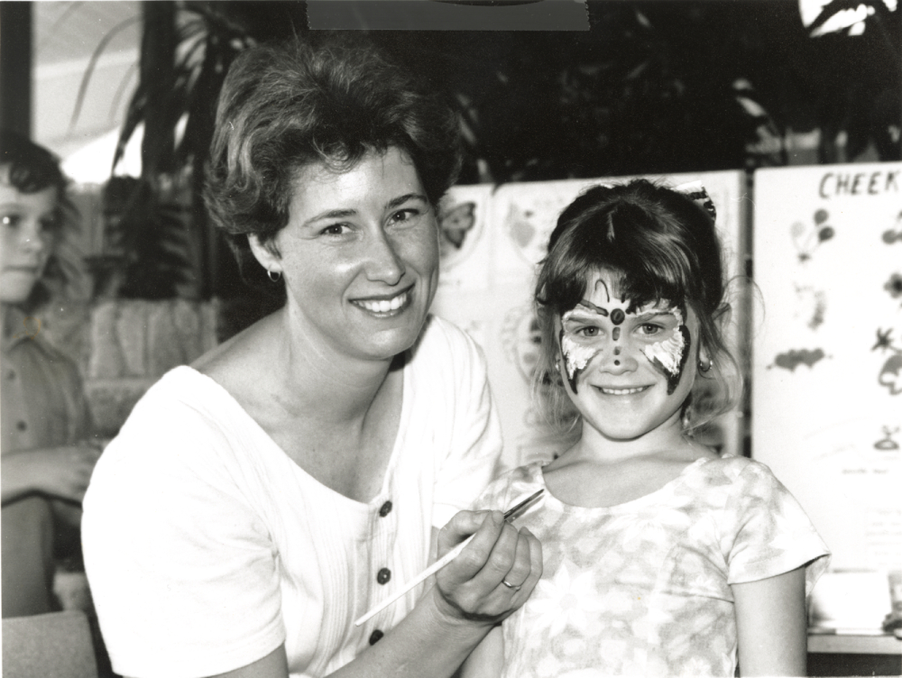 Face painter Yvonne Harris with Erin Davey, Redbank Plains Library, 1990s