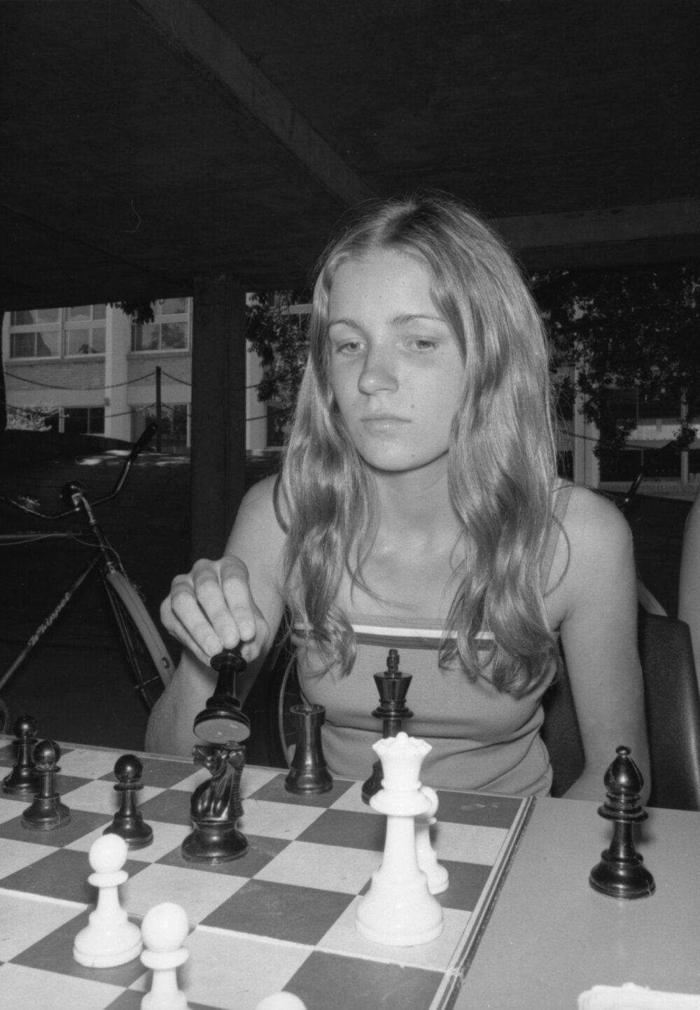 Unidentified girl playing chess outdoors, Ipswich, January 1978
