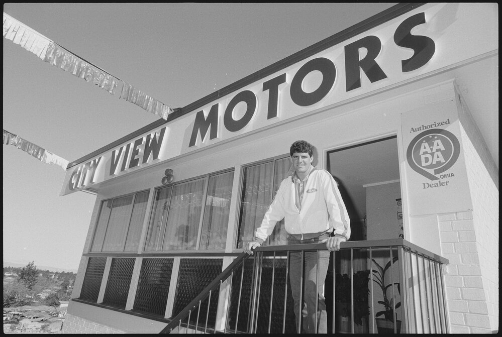 Mark Cumming standing at a City View Motors storefront, Ipswich, July 1985