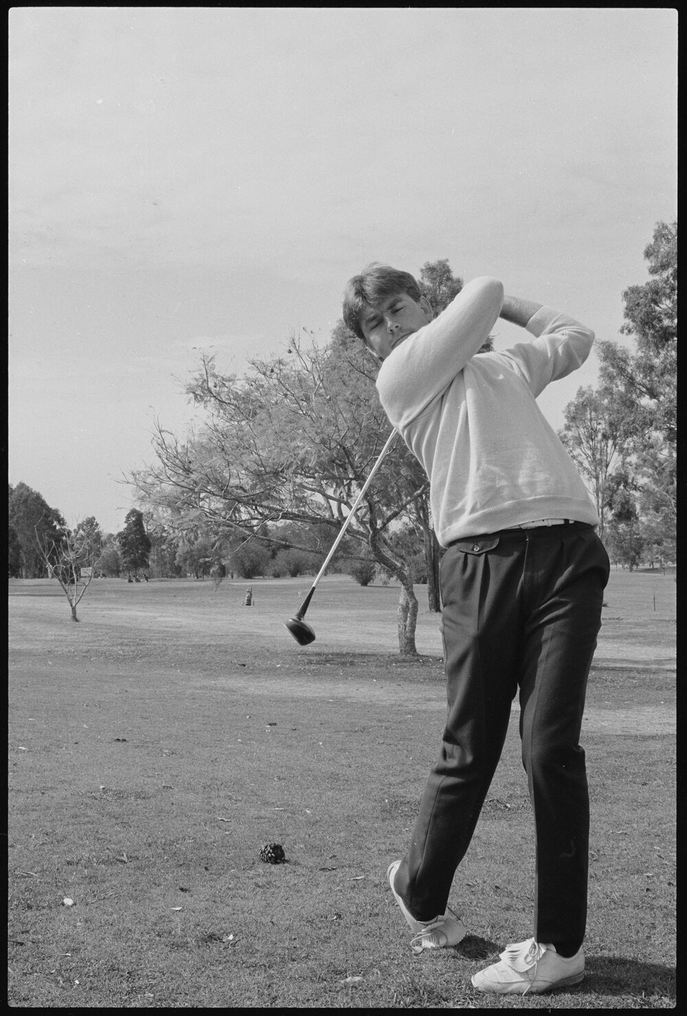 Unidentified man playing golf, location unidentified, August 1985