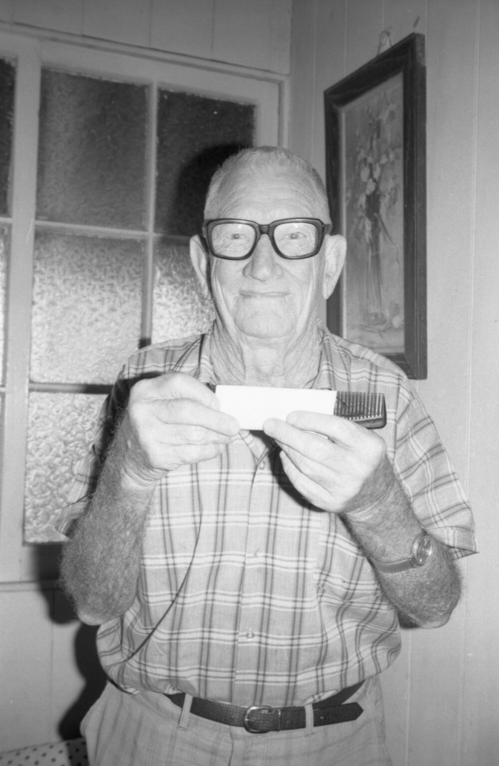 Unidentified man using a comb and paper to create an instrument, Ipswich, December 1977