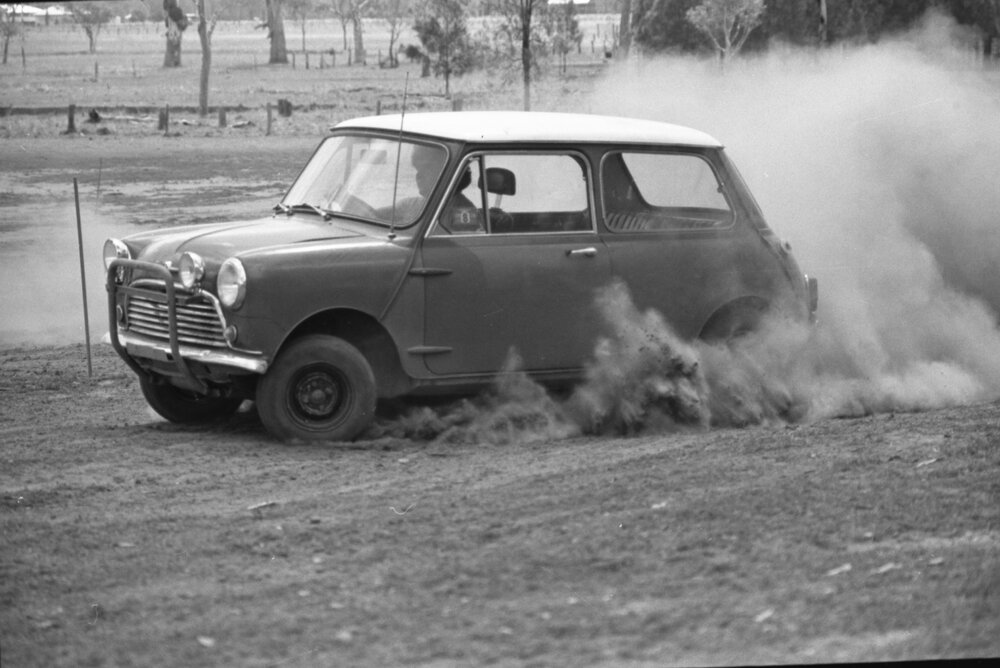 Man driving Morris Mini-Minor down dirt track, Ipswich, Queensland, January 1978