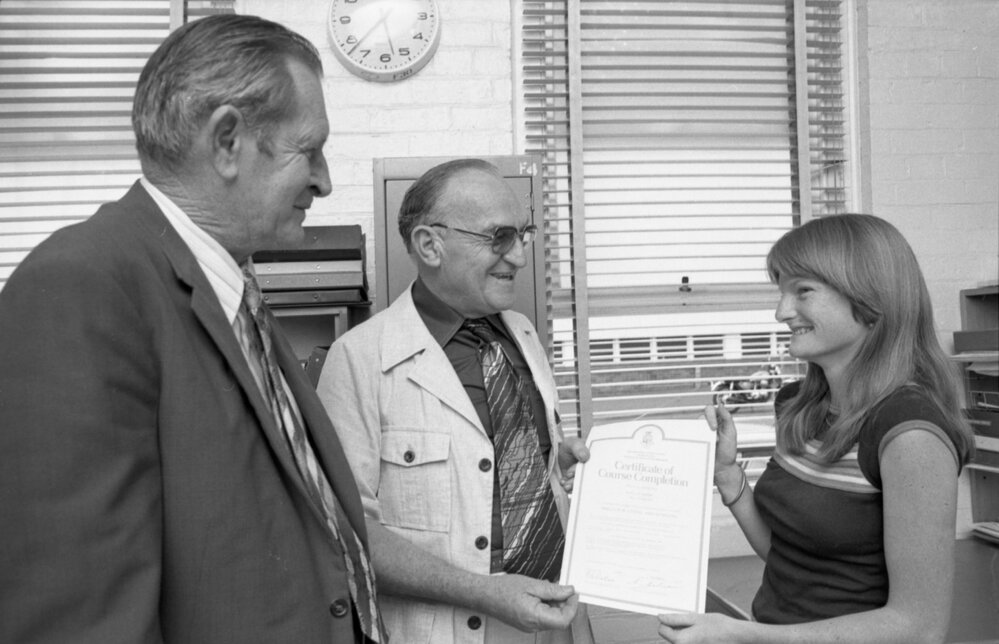 Young woman awarded a Certificate of Course Completion for an unemployment course, Ipswich, December 1977