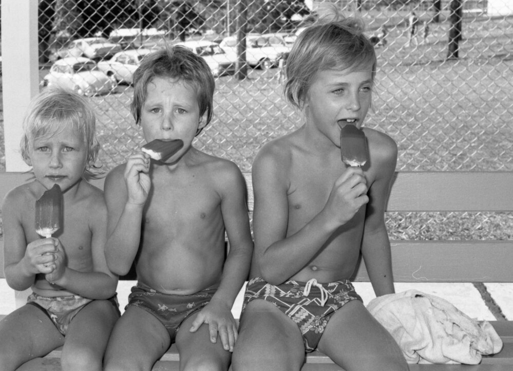 Three boys eating ice creams at a pool, Ipswich, Queensland, January 1978