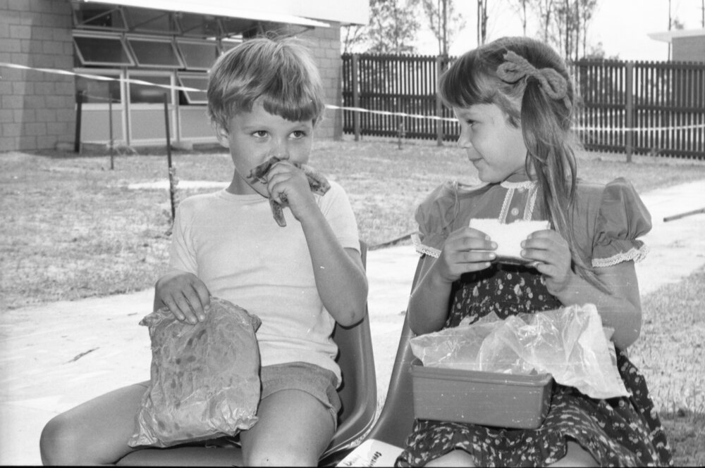Boy and girl eating lunch together at a school, Ipswich, Queensland, January 1978