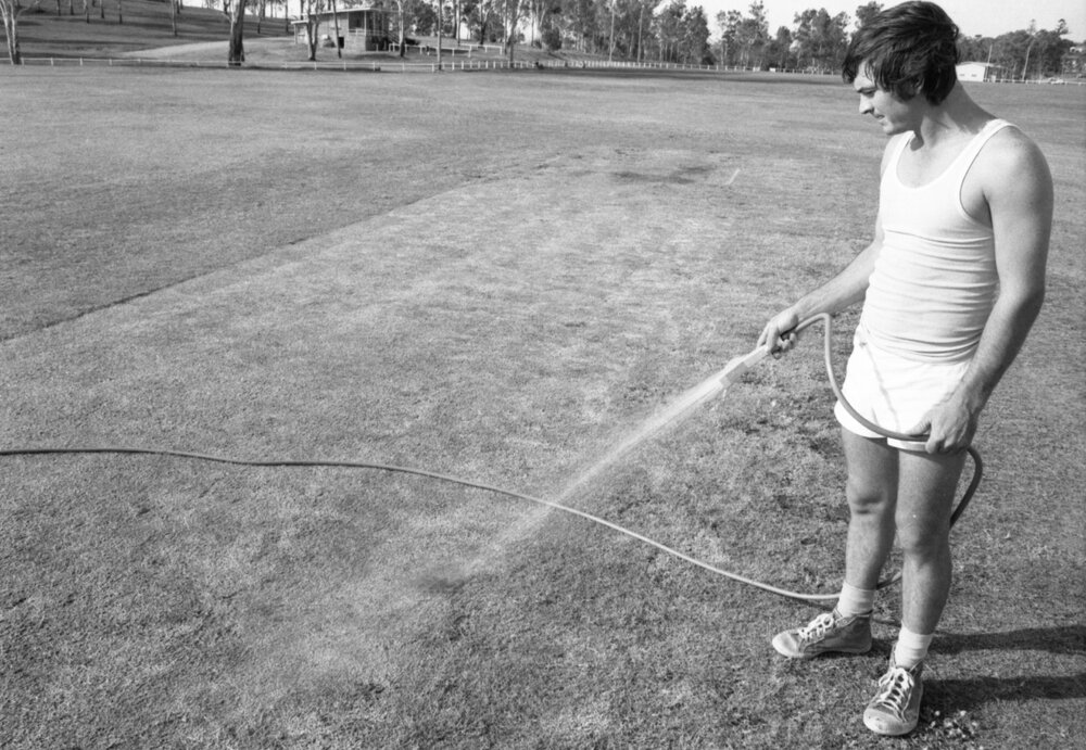 Man watering cricket field, Ipswich, Queensland, January 1978