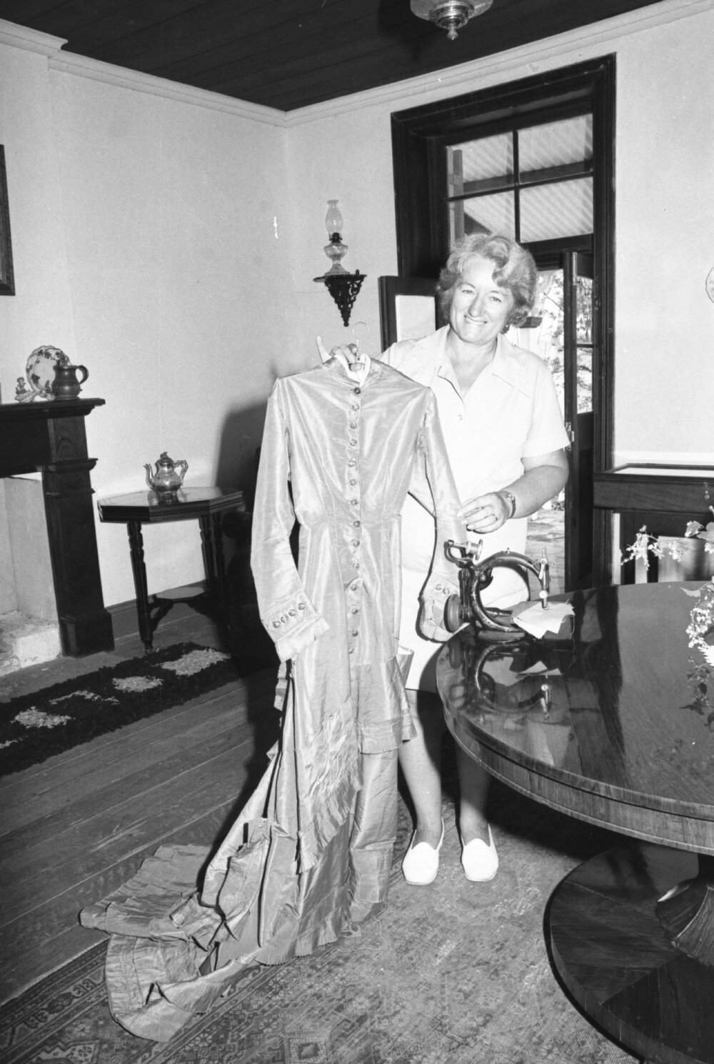 Mrs Wass displaying a dress inside Wolston House, Wacol, Queensland, January 1978