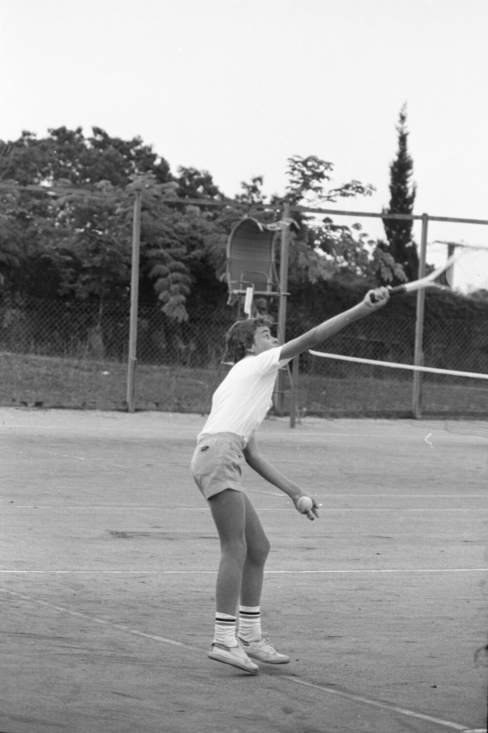 Man beginning a tennis serve, Ipswich, January 1978
