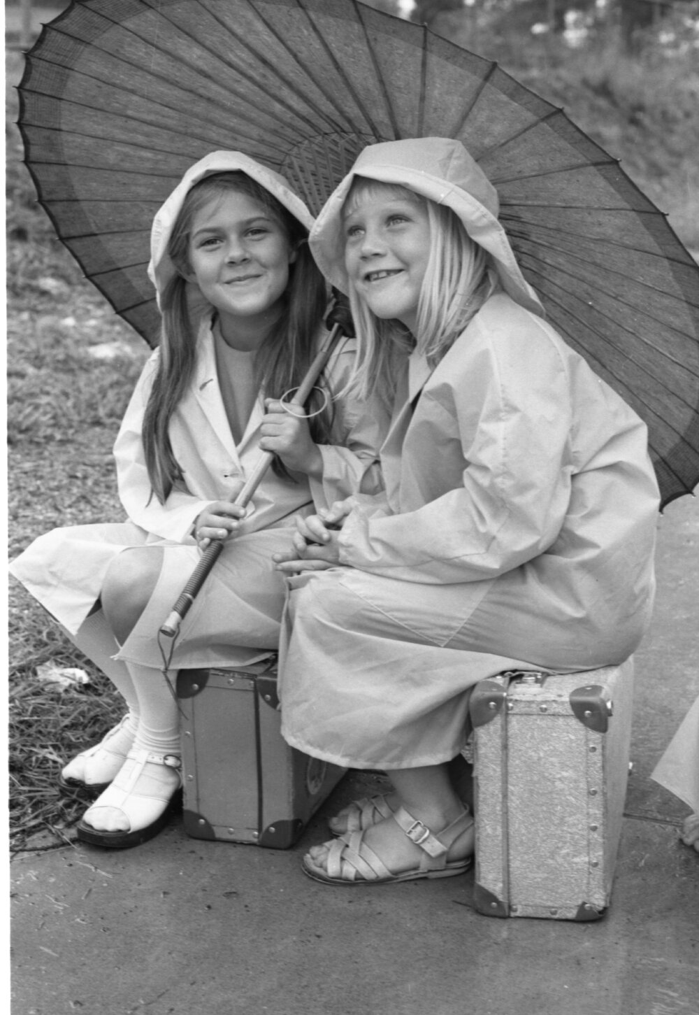 Girls with raincoats and umbrella in the rain, Ipswich, January 1978