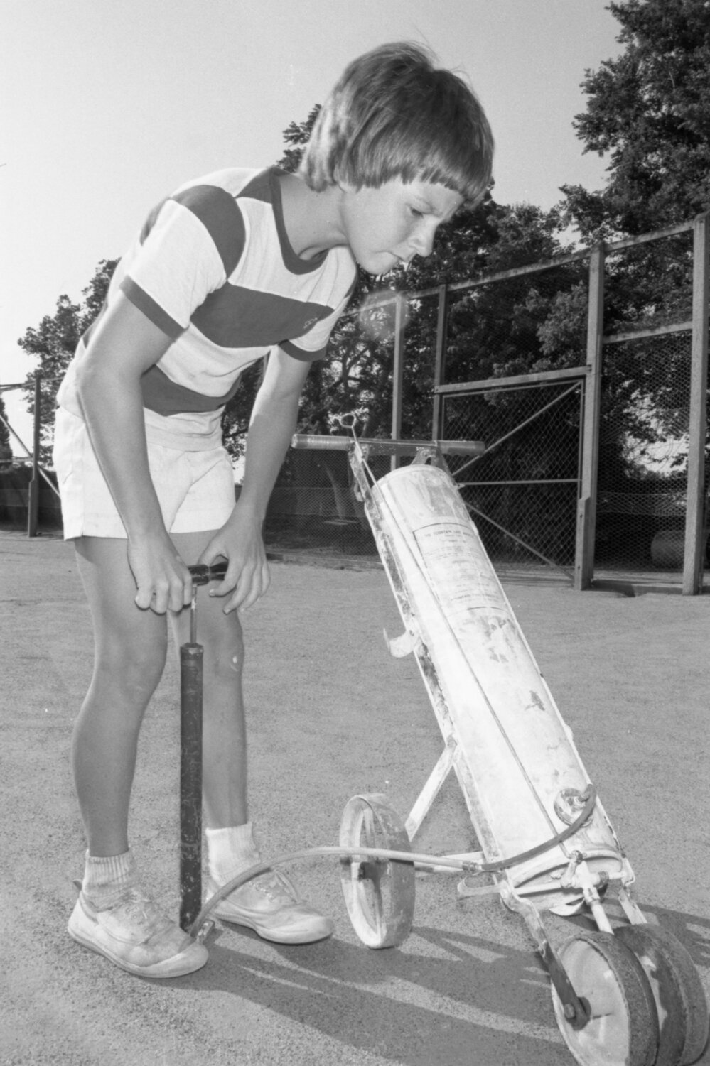Boy painting lines on a tennis court, Ipswich, December 1977