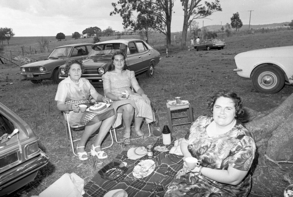 Women eating cake while picnicking, Ipswich, November 1977
