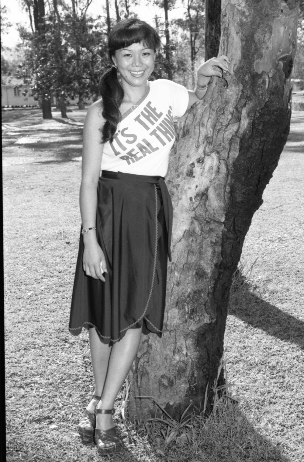 Young woman posing outdoors in text print shirt, Wacol, Brisbane, February 1978