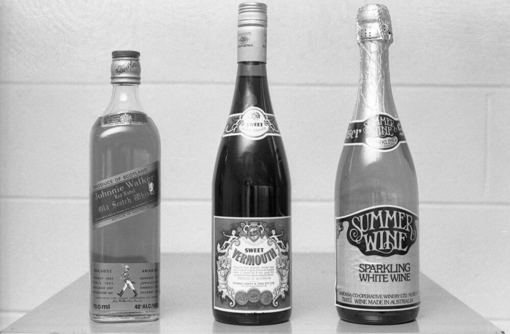 Bottles of Johnnie Walker Scotch Whiskey, Thomas Hardy Sweet Vermouth, and Summer Wine Sparkling White Wine, photographed by the Queensland Times for advertising, Ipswich, Queensland, February 1978