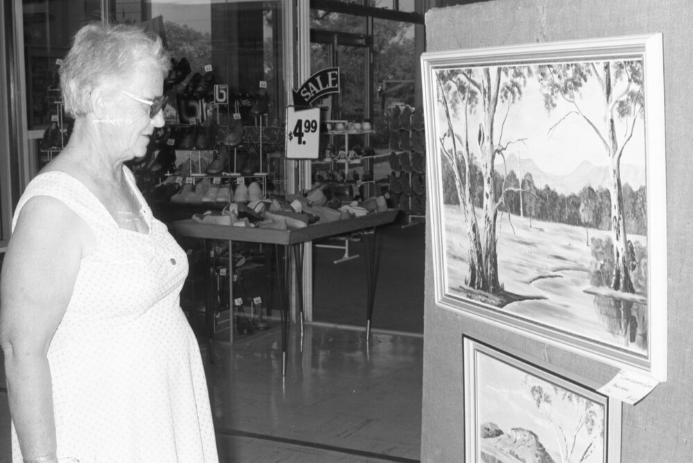 Woman admiring artwork outside a shoe store, Ipswich, Queensland, 15th February 1978