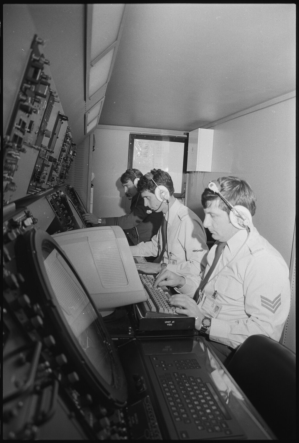 Three unidentified RAAF Airmen operating a control board, Ipswich, July 1985