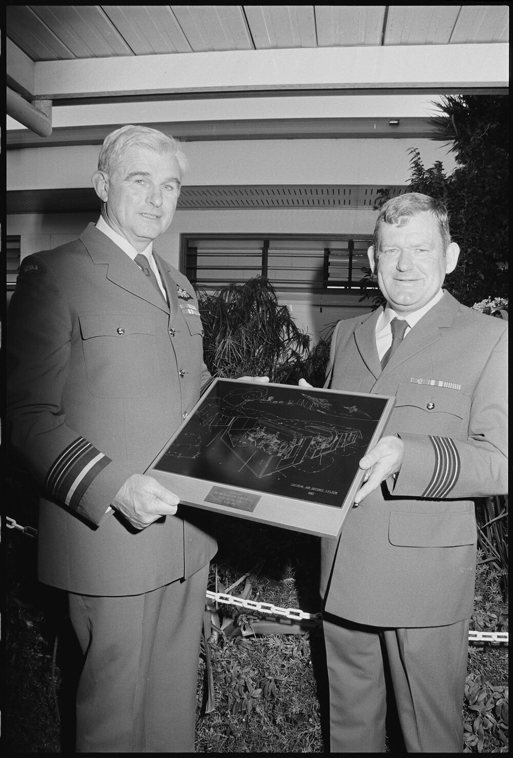 Unidentified man presenting Air Marshall John (Jake) Newham with a sketch of a RAAF Tactical Air Defence System, Ipswich, July 1985