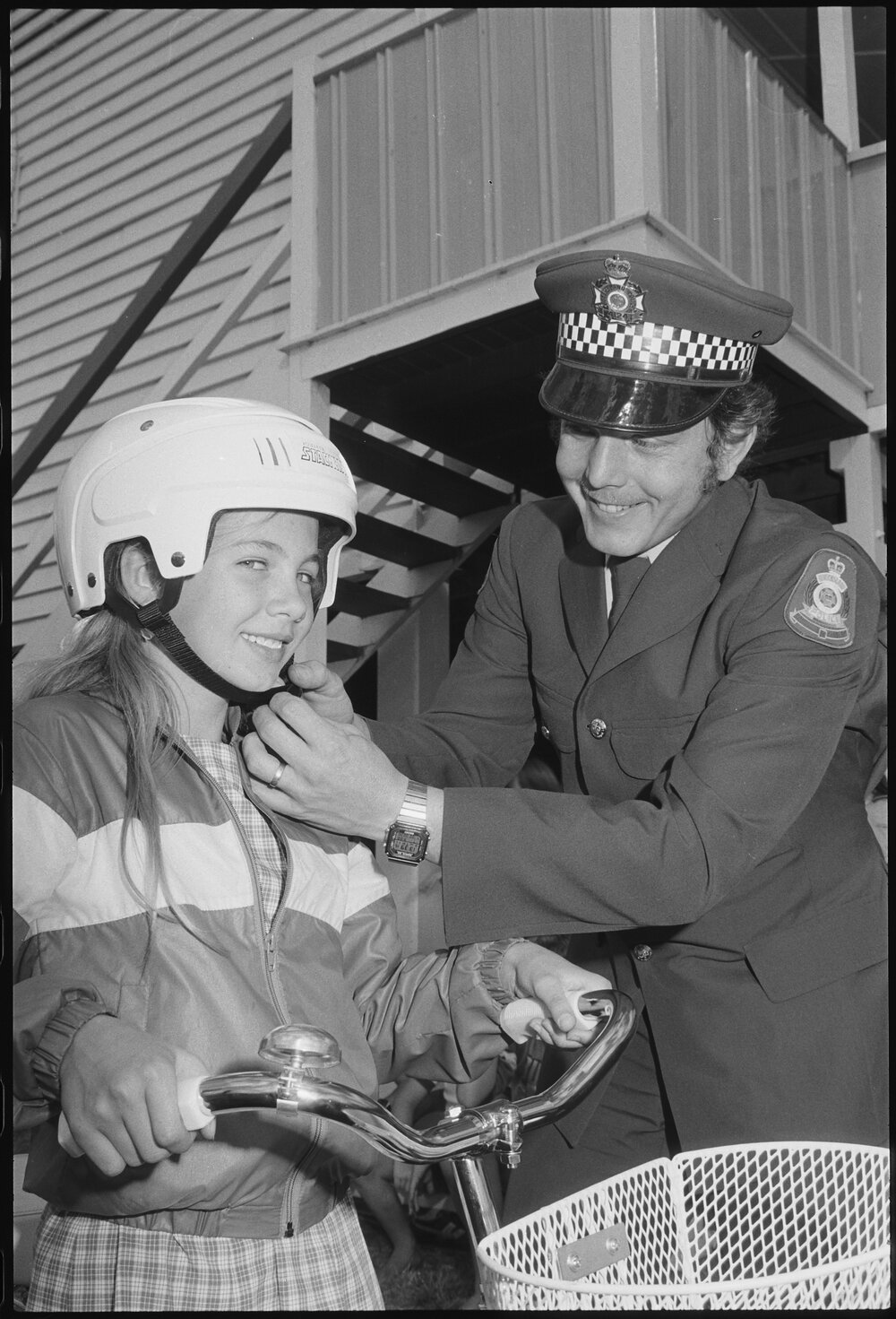 Unidentified girl participating in the Kalbar State Primary School Bike-a-Thon with police officer, Kalbar, July 1985