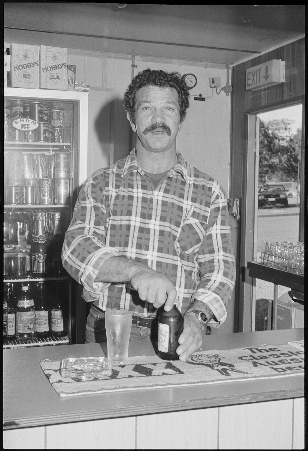 Unidentified bartender serving beer, Ipswich, July 1985