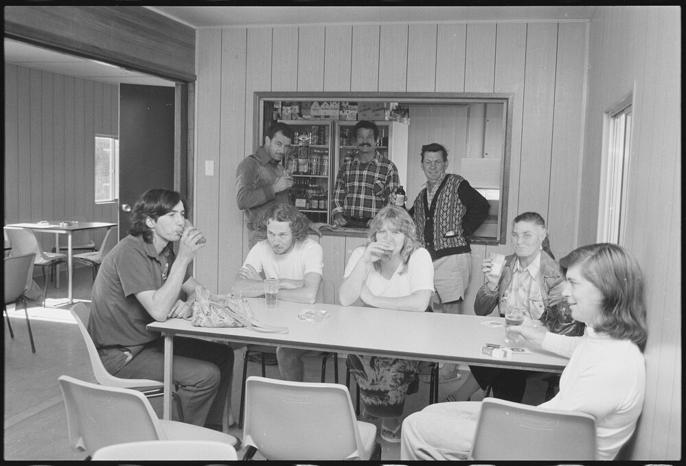 Unidentified bartender serving alcohol to a group, Ipswich, July 1985