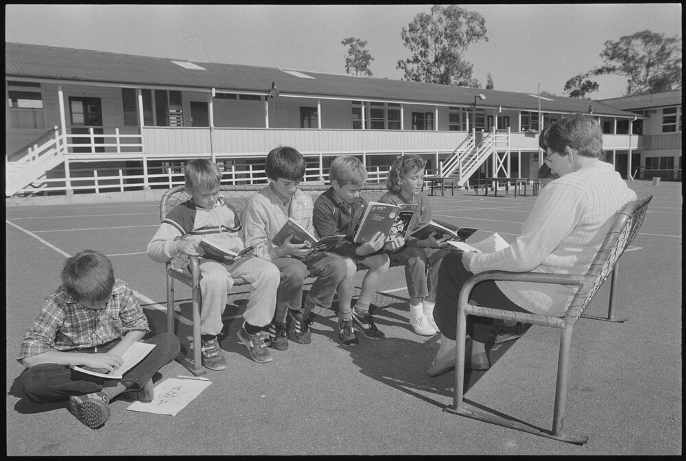 Unidentified students and teacher reading in an outside class, Ipswich, July 1985